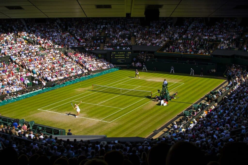 Prispengar Wimbledon. En match pågår mellan två kvinnliga tennisspelare på gräsunderlag.