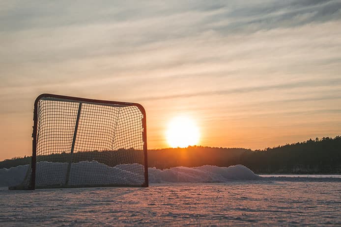 En solig vinterdag, ett hockeymål står tomt på isen.